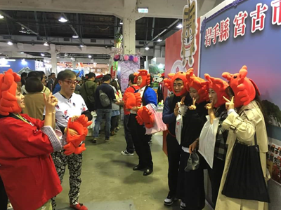 Visitors to the expo wearing a cap shaped like hairy crab