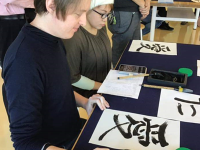 International participants trying Japanese calligraphy